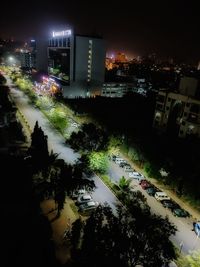 High angle view of illuminated street amidst buildings at night