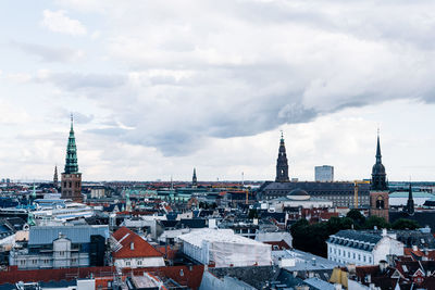 Christiansborg palace in city against cloudy sky