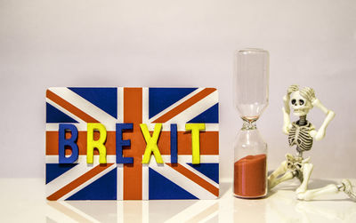 Close-up of multi colored glass on table against white background