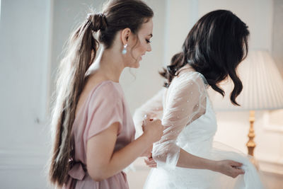 Bridesmaid grooming bride