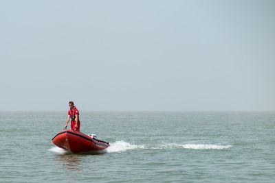 Man standing in sea against clear sky