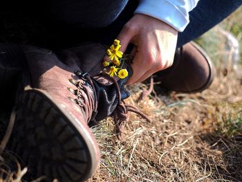 Low section of man wearing shoes while sitting on field