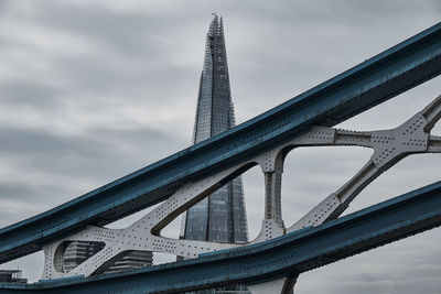 Low angle view of bridge against cloudy sky