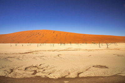 Scenic view of desert against clear blue sky