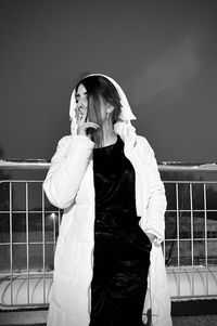 Young woman standing against clear sky