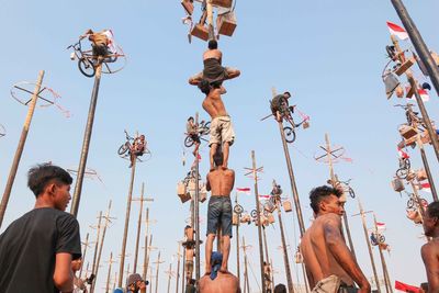 Low angle view of people looking away against sky