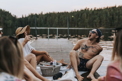 Happy friends sitting on jetty