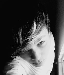 Close-up portrait of young woman over black background
