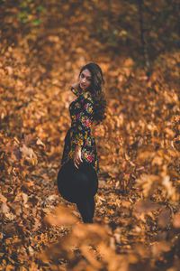 Woman standing with umbrella during autumn