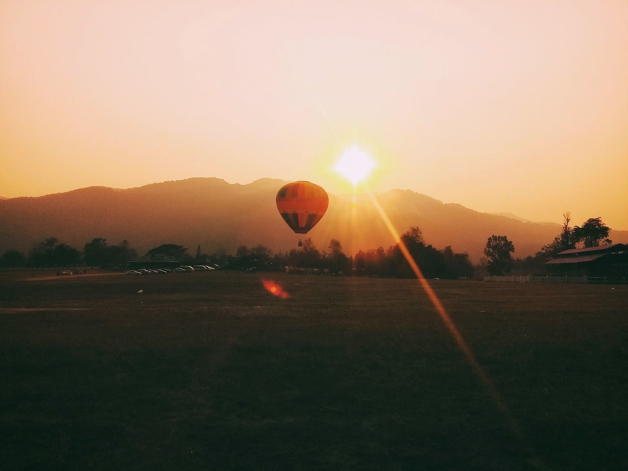 VIEW OF HOT AIR BALLOONS ON FIELD AGAINST SKY DURING SUNSET