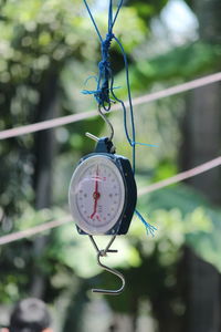 Close-up of clock hanging on metal chain