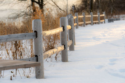 Wooden fence on snow covered field