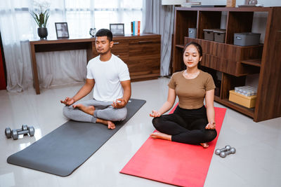 Portrait of young woman sitting on exercise mat