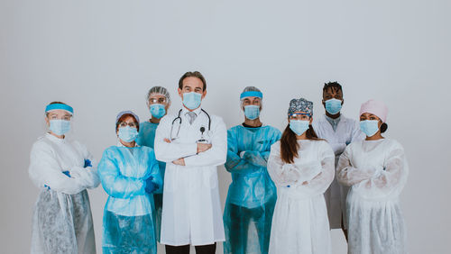 Doctors wearing mask standing against white background