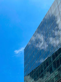 Low angle view of modern building against blue sky