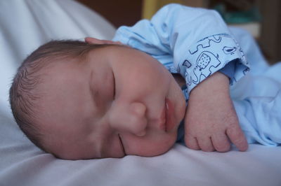 Close-up of baby boy sleeping on bed