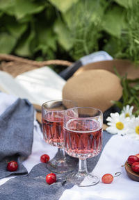 Picnic outdoors in lavender fields. rose wine in a glass, cherries and straw hat on blanket