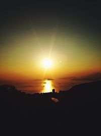 Scenic view of sea against dramatic sky during sunset