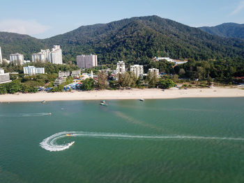 Scenic view of sea by city buildings