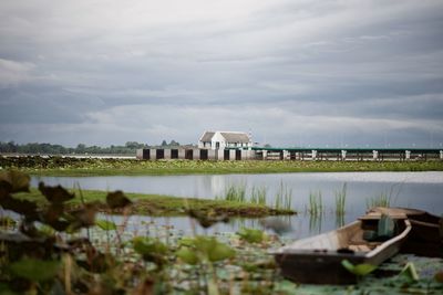 Built structure by lake against sky