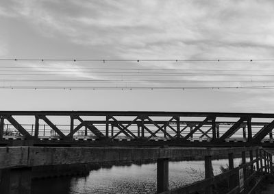 Low angle view of bridge over river against sky