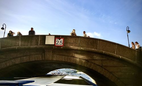 People on bridge against sky
