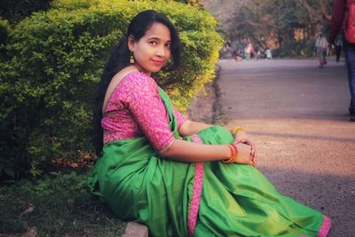 Portrait of smiling woman sitting outdoors