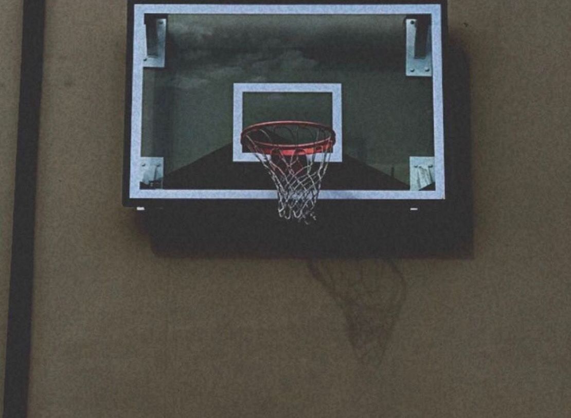 CLOSE-UP OF BASKETBALL HOOP IN THE BACKGROUND