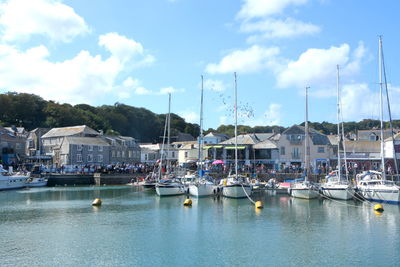 Sailboats moored in harbor