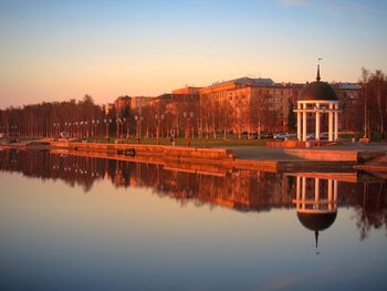 Reflection of buildings in lake at sunset