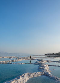 Man on beach against clear sky