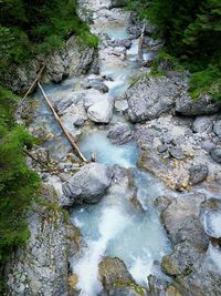 High angle view of stream flowing through rocks in forest