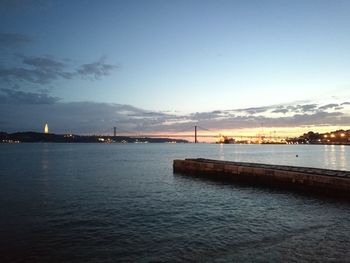 Scenic view of bay against sky at sunset