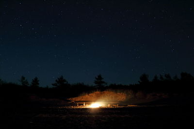 Bonfire on field against star field at night