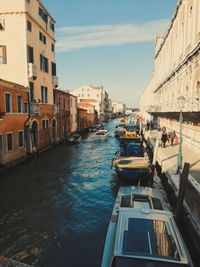 Canal amidst buildings in city against sky