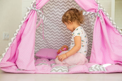 Portrait of cute baby girl sleeping on bed at home