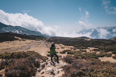 Rear view of man on mountain against sky