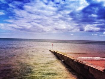 Scenic view of sea against cloudy sky