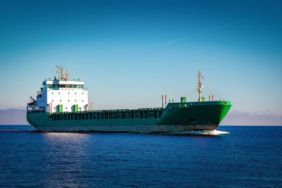 Ship in sea against clear blue sky