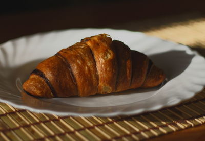 Close-up of croissant in plate on table