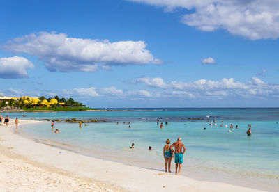 People at beach against sky