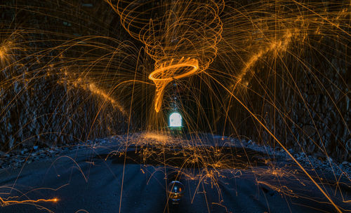 Light trails in illuminated tunnel at night