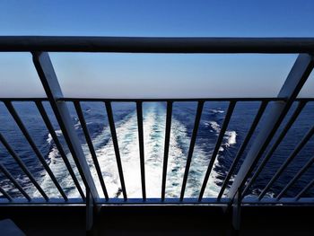 Scenic view of sea against clear blue sky seen through window
