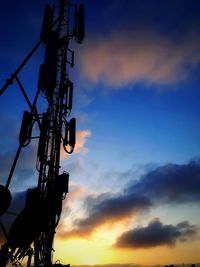 Low angle view of silhouette communications tower against sky during sunset