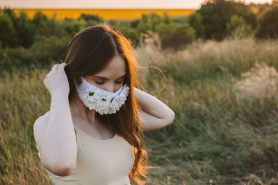 Close-up of young woman wearing mask standing outdoors