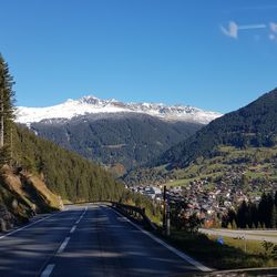 Road amidst snowcapped mountains against sky