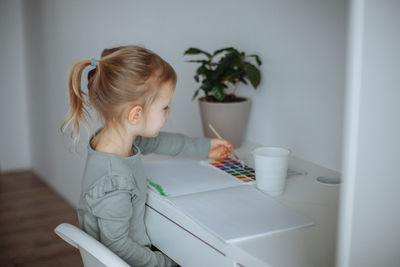 Side view of girl playing with toy at home