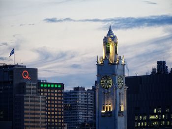 Illuminated buildings in city against sky