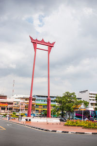 Red umbrella against sky in city