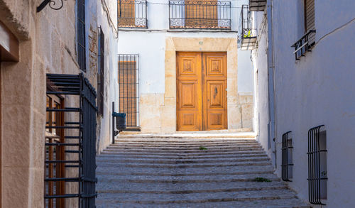 House with large wooden doors, at the end of a stepped village street.